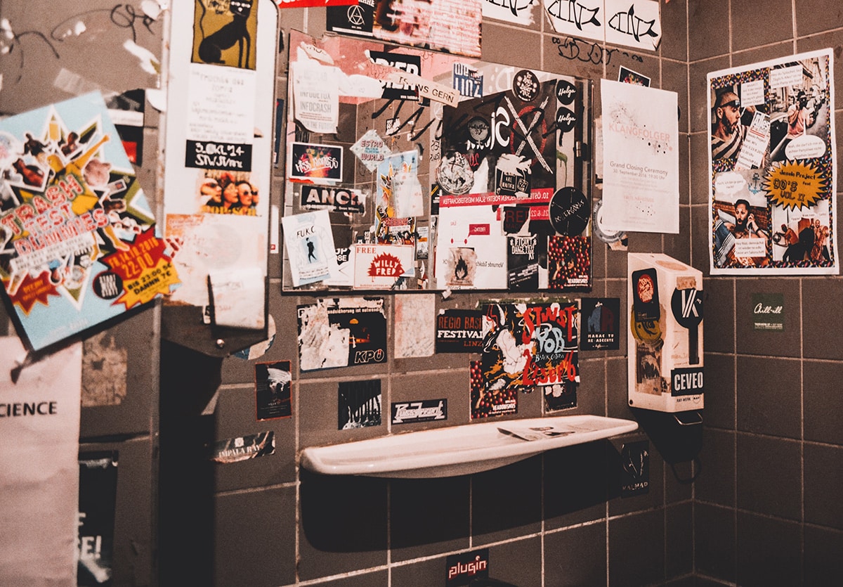 a public bathroom covered in stickers and posters