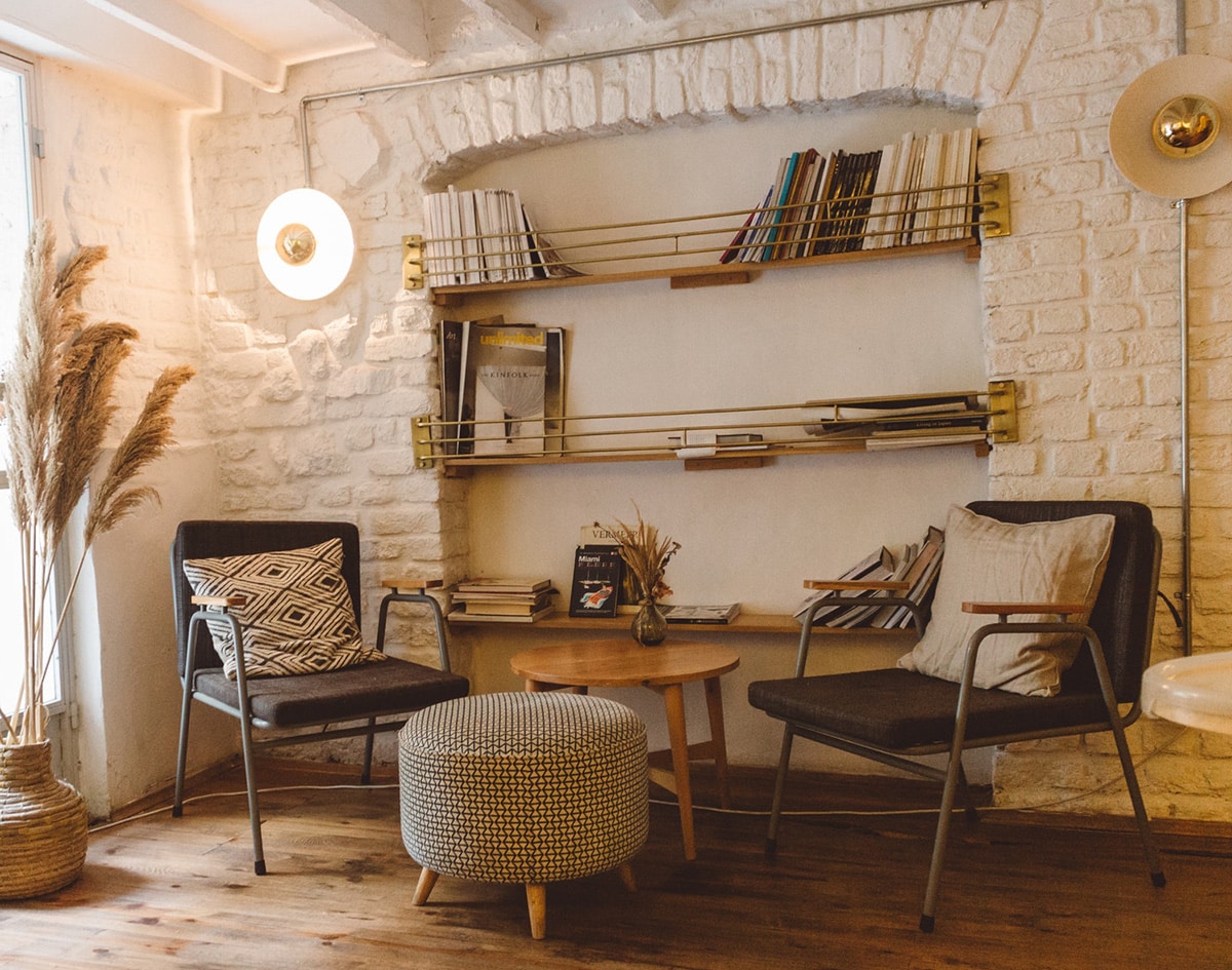 a warm lit reading area by a white painted brick wall