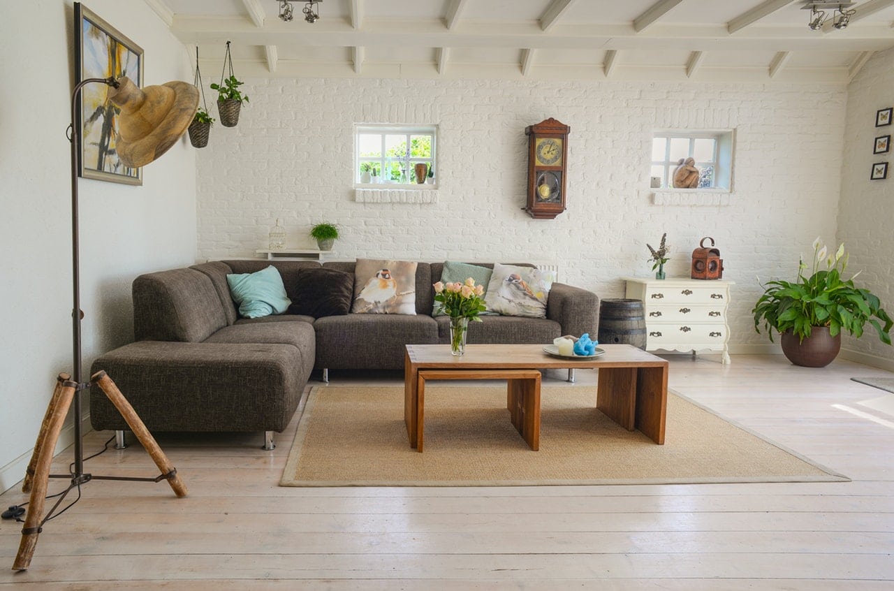 a white brick living room with brown furniture